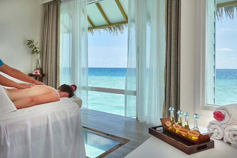 person being massaged in an over water room on the ocean