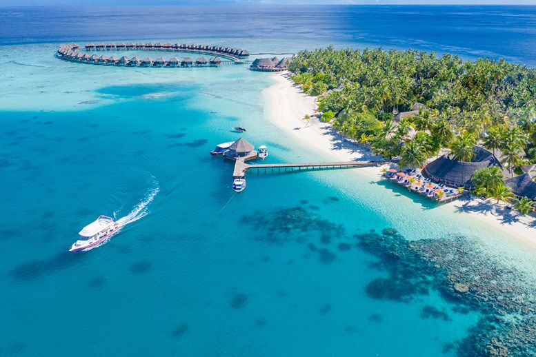 aerial view of vilu reef resort. boardwalk view with boat leaving