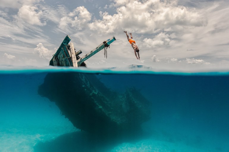 man diving off the shipwreck experience